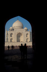 Silhouette of tourists in front of building