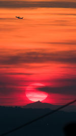 Low angle view of airplane wing at sunset