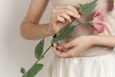 Midsection of woman holding flower
