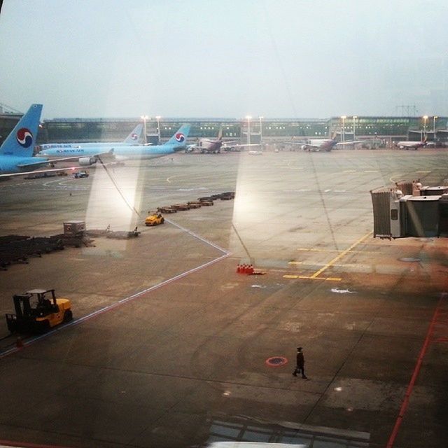 transportation, mode of transport, built structure, car, architecture, airplane, travel, land vehicle, sky, city, nautical vessel, road, air vehicle, airport, incidental people, building exterior, street, on the move, road marking, outdoors