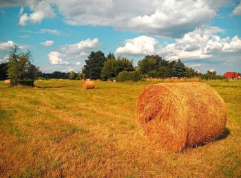 Hay bales on field against sky