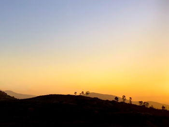 Scenic view of silhouette mountain against clear sky during sunset