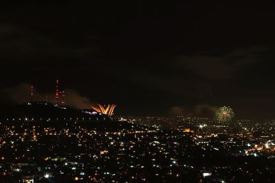 High angle view of illuminated buildings against sky at night