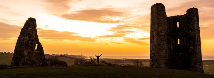 Castle on field against sky during sunset