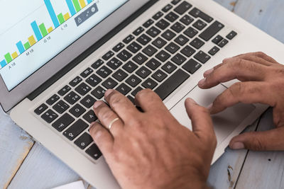 Low section of person using laptop on table