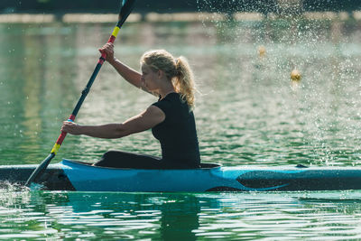 Young woman kayaking on lake