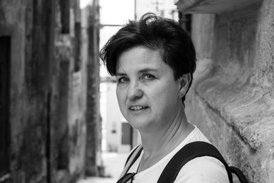 Close-up portrait of smiling woman against wall