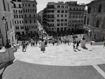 People on street amidst buildings in city