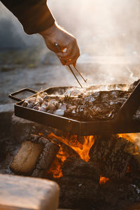 Close-up of person preparing food on barbecue grill