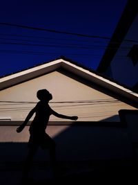 Silhouette man standing against clear sky during sunset