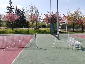 Empty benches in park against sky