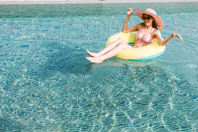 Woman in inflatable ring on swimming pool