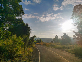 Road amidst trees against sky