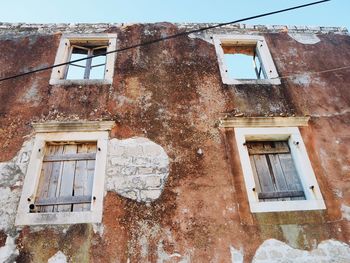 Low angle view of abandoned house against sky