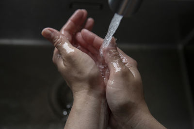Close up of caucasian person washing their hands in the sink