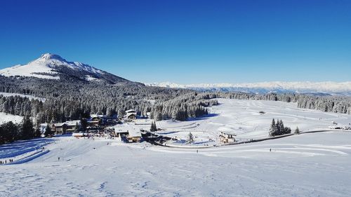 Scenic view of snowcapped mountains against clear blue sky