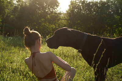 Rear view of woman with dog on field