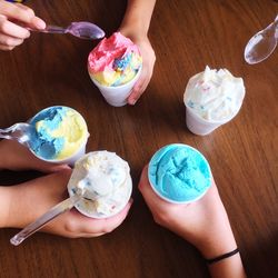 Hands holding ice cream cups 