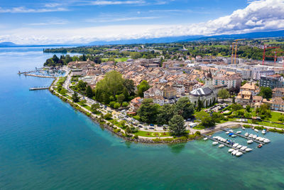 High angle view of townscape by sea against sky