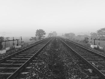 Railroad tracks on field against sky