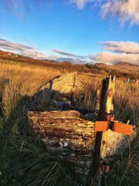 Wooden posts on field against sky