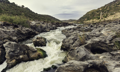 Scenic view of waterfall against sky