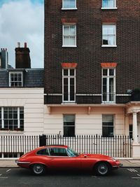 Cars on road by buildings in city