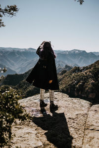 Man standing on mountain against clear sky