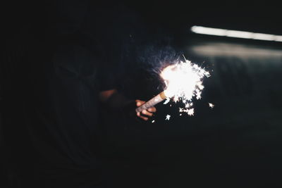 Close-up of hand holding sparkler at night