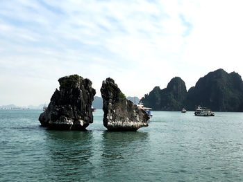 Scenic view of rocks in sea against sky