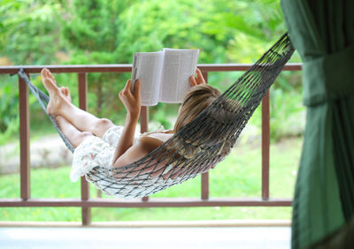 Side view of woman relaxing on hammock