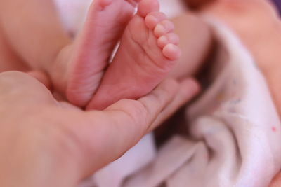 Cropped hand of person holding baby feet