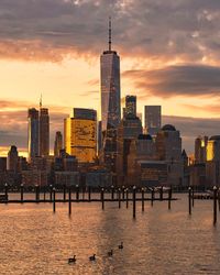 Skyscrapers in city at sunset