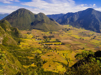 Scenic view of field and mountains against sky