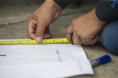 Close up of carpenter measuring plank