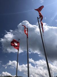 Low angle view of flag flags against sky