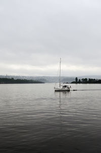 Sailboat sailing on lake against sky