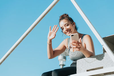 Portrait of smiling young woman using mobile phone