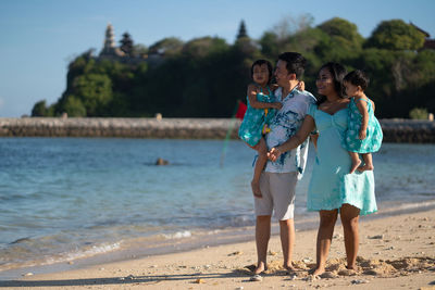 A young family with two children on a beach vacation in bali