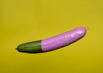 Close-up of purple chili pepper on yellow background