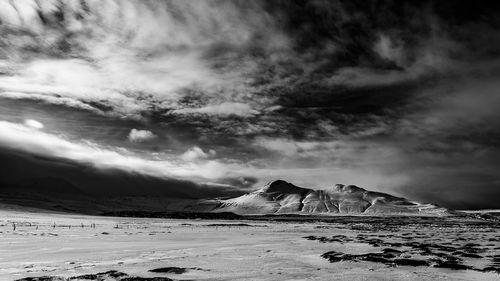 Scenic view of mountains against cloudy sky