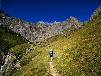 Rear view of man walking against mountain range