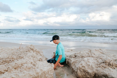 Boy on beach against sky