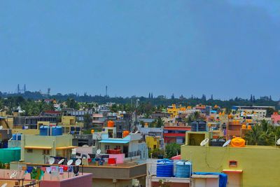 Houses and buildings against clear blue sky