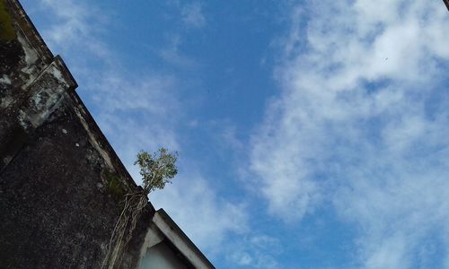 Low angle view of building against cloudy sky