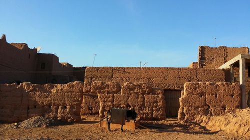 Man standing by built structure against clear sky