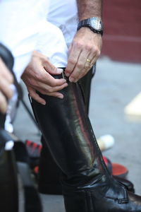 Low section of polo player wearing riding boot