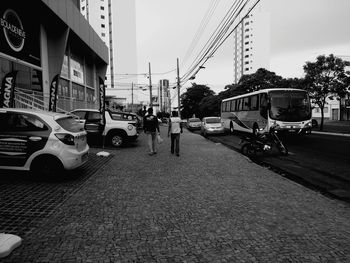 Cars on street in city against sky