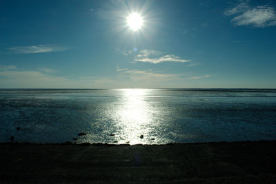 Scenic view of sea against bright sun