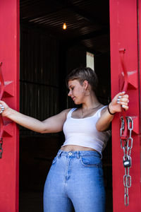 Full length of woman standing against red door